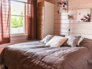 a bed in a bedroom with a window at Holiday Home Aurinko-saaga 5 paritalo by Interhome in Hyrynsalmi