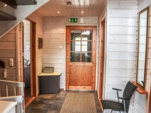 a hallway of a tiny house with a wooden door at Holiday Home Aurinko-saaga 5 paritalo by Interhome in Hyrynsalmi