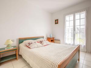 una camera da letto bianca con un letto e una finestra di Holiday Home L'Albizia by Interhome a Gujan-Mestras
