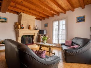 un soggiorno con 2 divani in pelle e un camino di Holiday Home L'Albizia by Interhome a Gujan-Mestras
