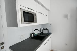 a kitchen with a sink and a microwave at Blue Sky Apartments Rezydencja Niechorze - 302 in Niechorze