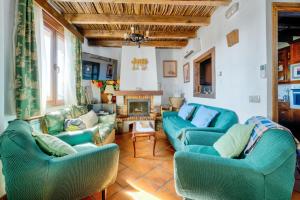a living room with blue couches and a fireplace at 6 bedrooms villa with private pool furnished terrace and wifi at Puebla de Don Rodrigo in Puebla de Don Rodrigo