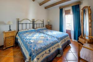a bedroom with a bed with a blue and white bedspread at Comfortable Villa in Puebla de Don Rodrigo with Private Pool in Puebla de Don Rodrigo +24 photos