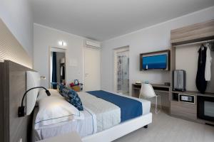 una camera d'albergo con un letto e una televisione di Scrusciu du mari a San Vito lo Capo
