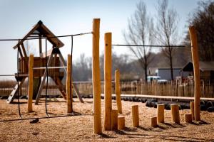 a playground with a slide and a swing at Camping At Sea in Dronten