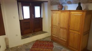 een kamer met een houten kast en een raam bij Athina Guesthouse in Monemvasia