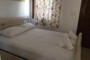 a white bed with two folded towels on it at Villa Christina in Kithnos