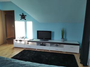 una sala de estar con TV en un centro de entretenimiento blanco en U Agnieszki, en Krynica-Zdrój