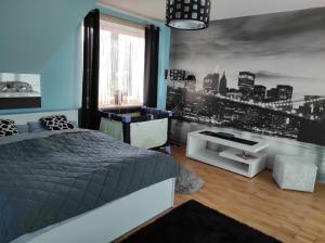 1 dormitorio con 1 cama y un mural con vistas al perfil urbano en U Agnieszki, en Krynica-Zdrój