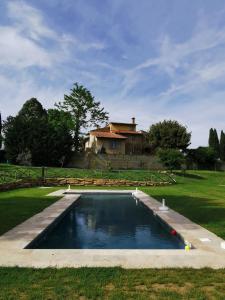 a pool of water with a house in the background at Teruzzi Country House in San Gimignano