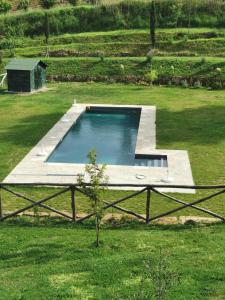 ein Pool in einem Garten mit einem Rasenplatz in der Unterkunft Teruzzi Country House in San Gimignano