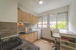 a kitchen with a sink and a desk with a chair at Top-Top in Podgorica