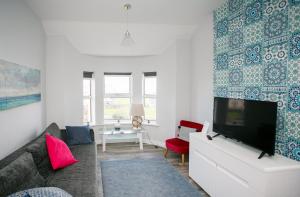 a living room with a couch and a tv at Apt3, No 2 Antrim Gardens, Portrush with Seaview in Portrush
