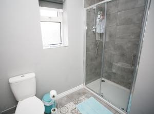 a bathroom with a shower and a toilet at Apt3, No 2 Antrim Gardens, Portrush with Seaview in Portrush +23 photos