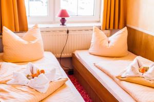 two beds in a hotel room with towels and pillows at Hotel Gorch Fock in Timmendorfer Strand