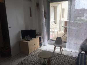 un salon avec une télévision, une table et une fenêtre dans l'établissement Bel appartement, à Berck-sur-Mer