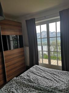 a bedroom with a bed and a large window at Ferienhof Gassner in Mondsee