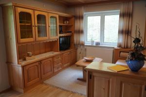 a large kitchen with wooden cabinets and a table at Haus "Die Zinne" in Außervillgraten