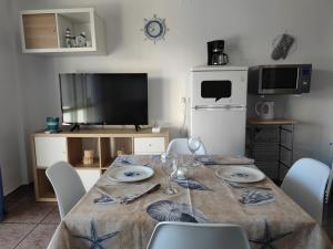 uma sala de jantar com uma mesa com cadeiras e uma televisão em Apacos muy cerca playa Entrada Autónoma em Algarrobo