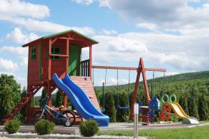 a playground with a slide and a play structure at Eplényi Apartmanház in Eplény