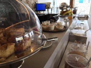 a buffet line with cakes and desserts on a counter at V-rooms in Milos Cyclades in Pollonia
