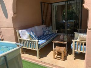 a porch with a couch and a table on a patio at CASA 4 HABITACIONES CON JARDIN Y PISCINA 10 Pax in Zahara de los Atunes
