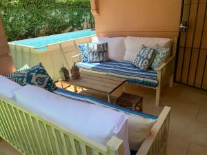 a porch with a couch and a table at CASA 4 HABITACIONES CON JARDIN Y PISCINA 10 Pax in Zahara de los Atunes