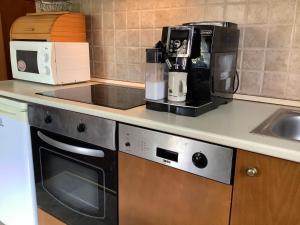 a kitchen counter with a coffee maker and a microwave at Apartman Golf Lux in Bük