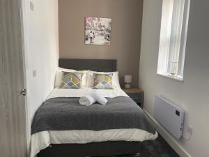 a bedroom with a bed with two towels on it at 2D SPV Double En-suite Room in Wakefield
