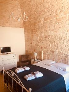 1 Schlafzimmer mit 2 Betten und Ziegelwand in der Unterkunft Nido di pietra-dimora in centro in Alberobello