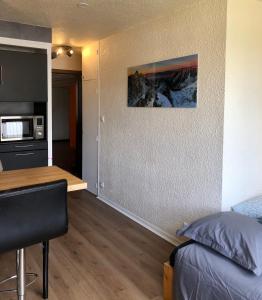 Habitación con cama y cocina con mesa en Studio lumineux neuf dans l'hyper centre avec vue en Chamonix-Mont-Blanc