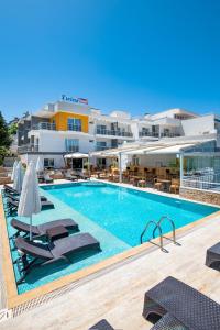 a large swimming pool with chairs and a hotel at Twins Hotel Çeşme in Cesme