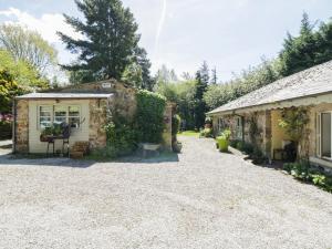 a house with a gravel driveway next to a building at Redwood Lodge in Wrexham