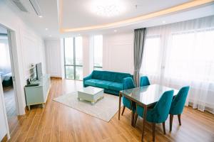 a living room with a blue couch and a table at Khách sạn VHL Hà Nam in Phủ Lý