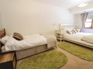 2 camas en una habitación con alfombras verdes en Redwood Lodge en Wrexham