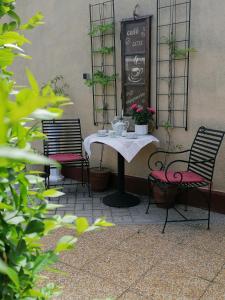 ギェネシュディアーシュにあるMarianna Apartmanのテーブル(椅子2脚付)とテーブル(花付)