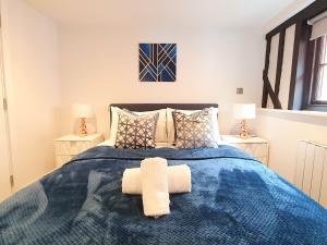 ein Schlafzimmer mit einem blauen Bett mit zwei Handtüchern darauf in der Unterkunft Stansted Airport Luxury Apartment Bishops Stortford Millars One Loft 4 in Bishops Stortford