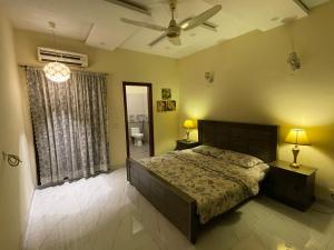 sypialnia z łóżkiem i wentylatorem sufitowym w obiekcie Lovely 1-Bed House in Lahore w mieście Lahaur
