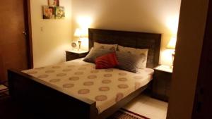 a bedroom with a large bed with two night stands at Eden Apartment Sleeps 6 with Pets in Lahore +5 photos