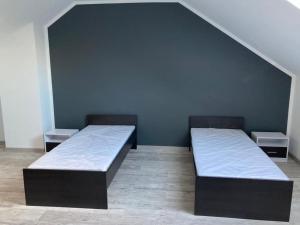 2 Betten in einem Zimmer mit blauer Wand in der Unterkunft Domek in Cammin in Pommern