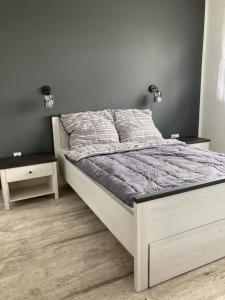 a white bed in a bedroom with two night stands at Domek in Kamień Pomorski