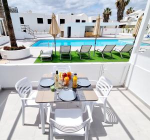 stół i krzesła na balkonie z basenem w obiekcie Luxury Atlantico View w Puerto del Carmen