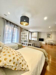 een slaapkamer met 2 bedden en een woonkamer bij Apartamentos San Antonio in Aranda de Duero