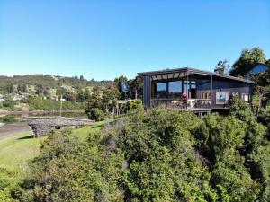 a glass house on top of a hill at CASA BARCA DE CHILOÉ in Castro