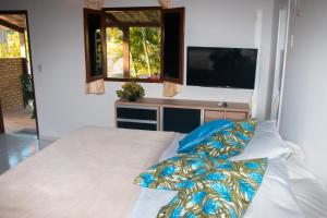 a bedroom with a bed with a television in it at Pousada Cacimbinha - ePipa Hotéis in Pipa