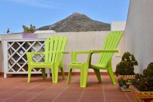 two green chairs sitting on top of a patio at Casa Nettuno Favignana in Favignana