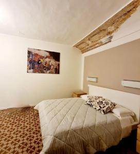シラクーサにあるCasa vacanze Simopieroのベッドルーム1室(ベッド1台付)が備わります。壁には絵画が飾られています。