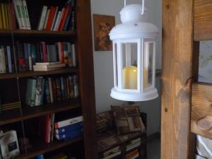 a candle in a lantern hanging from a book shelf at L'Elefantino - Bed and Book in Roccasparvera +9 photos