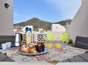 a table with a plate of food and glasses of orange juice at Casa Nettuno Favignana in Favignana