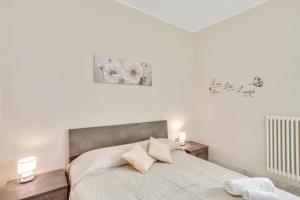 biała sypialnia z dużym łóżkiem z 2 lampami w obiekcie Casa Alessandra Terrace Flat in Conversano w mieście Conversano